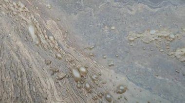 Renkli köpüklü kalın köpük. Şehirden gelen kirli lağım suyu akıntısı. Çürüyen tanklara giden yolda organik tortuları karıştırın..