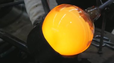 Cam üfleme düdüğünün üzerinde sıcak cam kırıklarıyla çalışan zanaatkar eller. Geleneksel cam şekillendirme tekniği. Kunratice 'de el yapımı cam stüdyo..