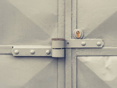 Güvenlik kilidi olan gümüş gri çift kapı. Endüstriyel bir kapı garaj binasına giriyor..