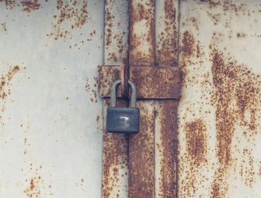 Terk edilmiş bir depo binasında kapalı bir giriş kapısı var.