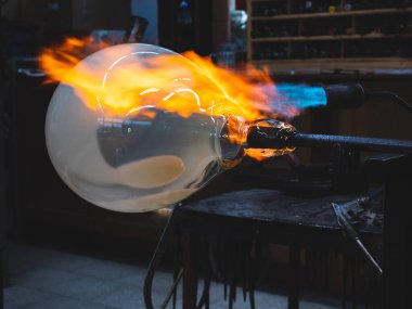 Sıcak Meşale ve cam üfleme piposuyla geleneksel cam sanatı yaratmak. Geleneksel yöntemle ağır cam kaseyi yaratmak