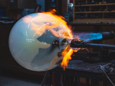 Zanaatkar eller sıcak cam ile çalışır ve gaz ocağıyla ısıtırlar. Sanatçının metoduna yakın çekim. Çek el yapımı cam stüdyo.