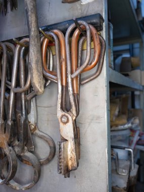 El yapımı sanat camlarını şekillendirmek için çeşitli şekillerde makas ve pense. Geleneksel araçlarla cam üfleyici atölyesi.