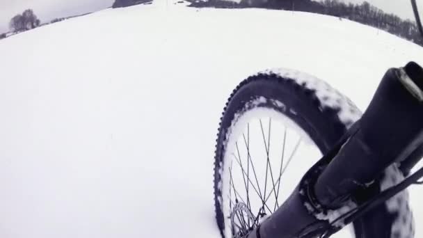 雪の中で自転車に乗る 雪の中でマウンテンバイクの前輪 夜の深い雪のドリフトの下でパスを失った オフロードタイヤの暗い上で融ける雪のフレーク 現地の冬の天気 — ストック動画