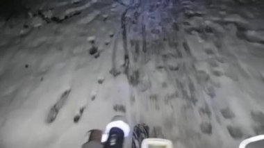 Gece karlı patikada bisiklete binen bisikletçi. Extreme Sport ve Enduro Bisiklet Konsepti. Karlı ve kaygan yol birkaç santimetre yapışkan karla kaplı.