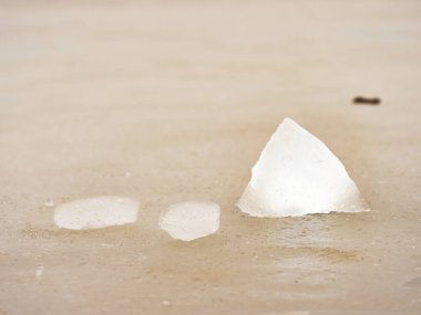 Pembe buz kütlesi ve renkli çamurlu su. Donmuş kutup suyunda donmuş kabarcıkların yapısı, yansımalı ıslak kenarlar..