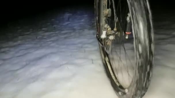 道の凍結した雪の上を跳ねるMtbの前輪に続く景色 冬の夜に滑りやすい地面に危険な乗り心地 — ストック動画