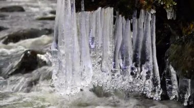 Buz saçağı derenin üzerinde, buz saçakları nehir suyunun üzerinde.