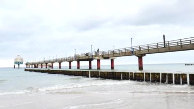 Denizin üzerindeki köprü, Zingst, Almanya 'da gondol ve iskele dalışı. Gökyüzüne karşı deniz aşırı iskele