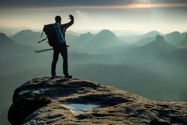 带着背包和手杖的远足者的轮廓正在高山和日落中飘扬 — 图库照片