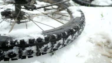 MTB 'nin arka tekerleği dönüyor. Bisikletin tekerleğini kapat. Kışlık ormandaki bisiklet bir tarafta duruyor. Yavaş çekim