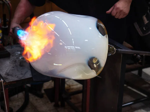ガラス管の上に火のトーチガラスボールを加熱します 国内のガラス設計スタジオで熱いガラスを形作る手 — ストック写真