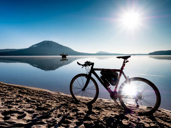 Trekking bike or gravel bike at lake on morning nature landscape background