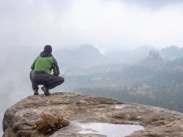 Homem Sentado Pico Uma Montanha Uma Manhã Nebulosa Sente Agachando — Fotografia de Stock