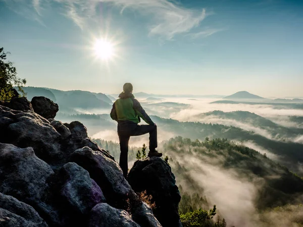 Single man hiker on a mountain trail. Mountain look into misty valley