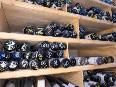 Cam baskı çubukları. Geleneksel cam işçiliği stüdyosunun rafında renkli cam çubuklar yığını.