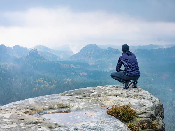 Man Sitting Peak Mountain Foggy Morning Sit Squatting Peak Edge — Stock Photo, Image