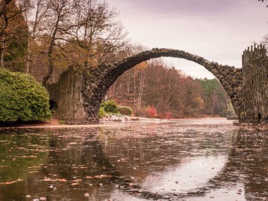 Rakotzbrucke 'nin etrafındaki yaprak döken ağaçta renkli yapraklar. Ayrıca Azalea' daki Şeytanlar Köprüsü ve Almanya 'daki Rododendron Park Kromlau,.