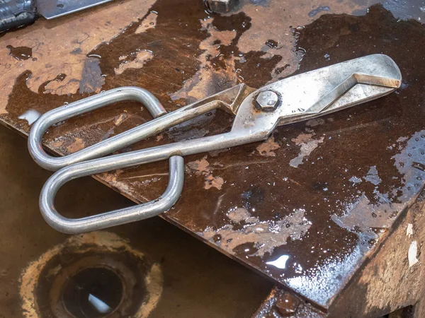 Diamond shear tool on wet steel table in glass blowing design studio