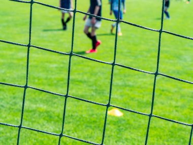 Futbol sahasında, iki takım futbol oynuyor.