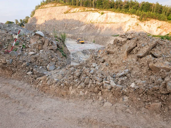 石の鉱山で働いているローダーブルドーザー 花崗岩の砂利の採石場 採掘された石の上の深い谷 — ストック写真