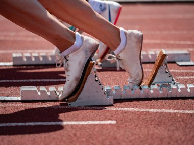 Foot Girls koşu pisti başlangıç bloklarında. Stadyumda atletizm eğitimi