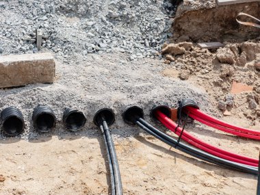 Yere yüksek voltaj kabloları döşenmiş. Elektrik kablosunu güvenli plastik tırnak tübüne yerleştirmek.