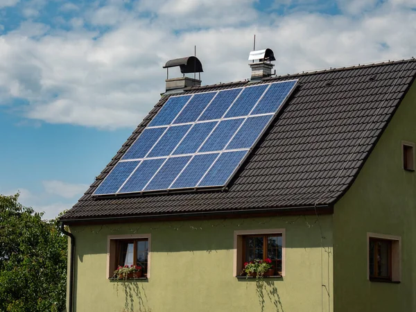 現代の屋根の上の一般的な太陽電池パネルは 電気の古いソースを置き換え 濃い青の光電池で — ストック写真