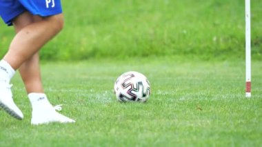 Sporcu çocuk parkında futbol topunu tekmeliyor. Orta yaşlı adamın hareketi. Otantik bir çevre, köy futbol sahasının iyi korunmuş çimenleri. Yavaş çekim
