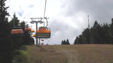 Yaz yamacının yukarısındaki teleferik kulübeleri, ormandaki vericili Klinovec tepesi..