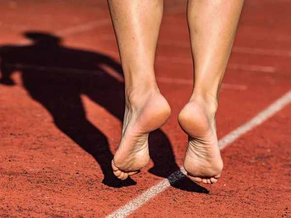 40歳の女性がスタジアムで晴れた朝に走る前に足を伸ばして — ストック写真