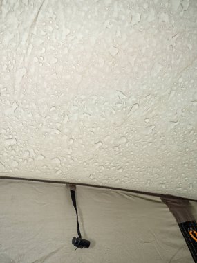 Yağmurdan sonra su geçirmez çadır kumaşı. Açık yeşil yürüyüş çadırından yapılmış hamile bir kumaş.