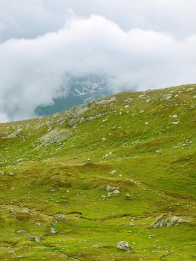 yüksek Alp Dağları'nın taşlı çayırlar. Kara Tepeler yoğun sisli bulutlar dokun. soğuk ve nemli gün sonunda Alp Dağları