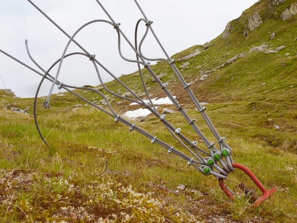 Procy i złom w zielone podwórze, żelaza skręcony sznur ustalony przez Śruby Karabińczyki i kółka na kotwicy w ziemi. — Zdjęcie stockowe