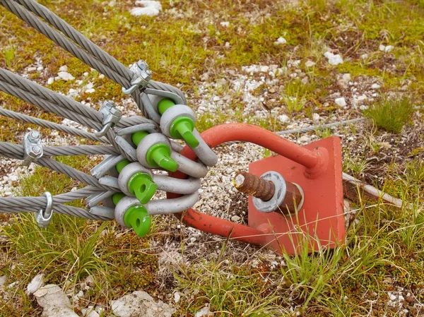 Twisted iron rope end in crews crome glittering snap hooks. Detail of thin strong rope end anchored at rock, climbers equipment