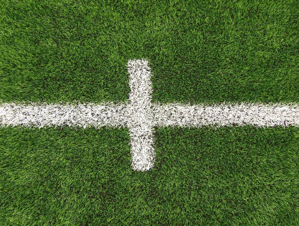 Widok zbliżenie się białe linie na polu sztucznej trawy na boisku piłki nożnej. Szczegóły Krzyża linii w boisko do piłki nożnej. z tworzyw sztucznych traw i drobno zmielony czarny gumowy. — Zdjęcie stockowe