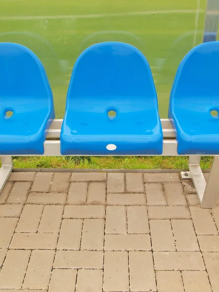 Nuovi sedili in plastica blu. Panchina per giocatori di calcio da stadio all'aperto, sedie con nuova vernice sotto il tetto di plastica trasparente . — Foto Stock