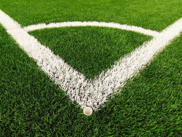 Campo da calcio angolo su tappeto erboso verde artificiale con segni di linea bianca dipinta. Gomma nera macinata in base — Foto Stock