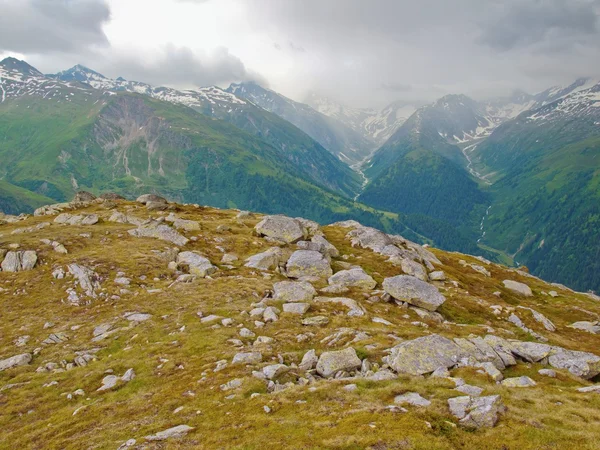 Automne en haute montagne alpine. Les sommets sombres touchent de lourds nuages brumeux. Fin de journée froide et humide dans les Alpes — Photo