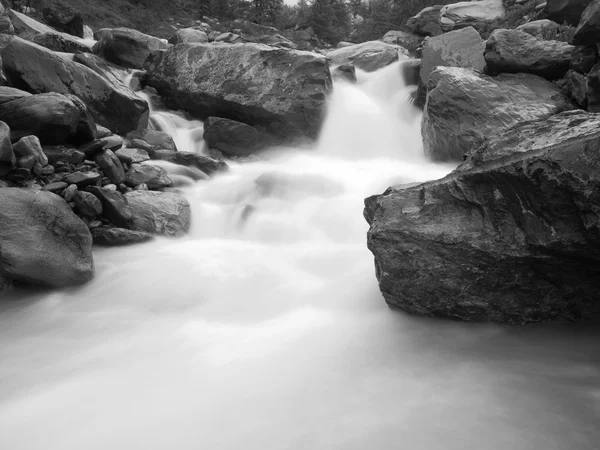 泡沫の高山の川の急な急速なストリームです。小川流れるダウン玉石および石、高水位大雨の後の白い波. — ストック写真