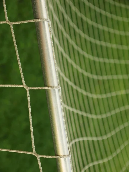 Hang bended soccer nets, soccer football net. Grass on football playground in the background — Stock Photo, Image