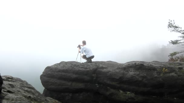 Fotoğrafçı ile tripod ayakta kayalık bakış ve puslu sabah manzara fotoğraflarını alarak. milli park Sakson İsviçre Almanya. melankolik sonbahar sabahı. — Stok video