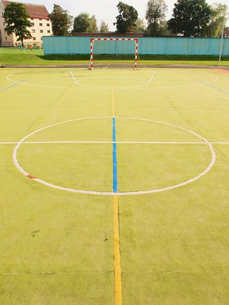 Espaço livre vazio do handball, superfície verde clara plástica na terra e linhas azuis brancas dos limites . — Fotografia de Stock