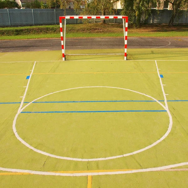 Espaço livre vazio do handball, superfície verde clara plástica na terra e linhas azuis brancas dos limites . — Fotografia de Stock