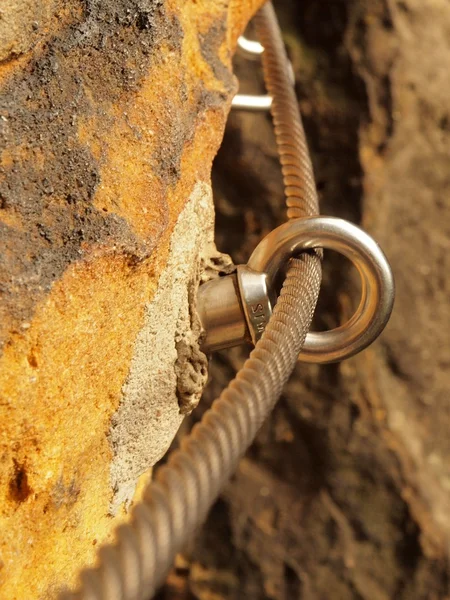 Détail de l'extrémité de la corde ancrée dans un rocher de grès. Corde torsadée en fer fixée en bloc par des vis mousquetons . — Photo