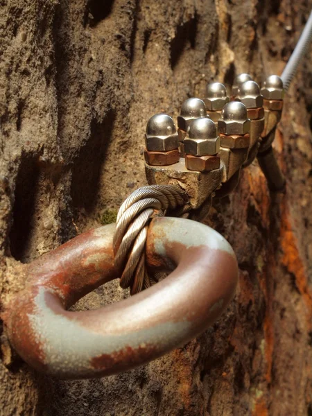 Eisen gedrehten Seil im Block durch Schrauben Karabinerhaken befestigt. Detail des im Sandsteinfelsen verankerten Seilenden — Stockfoto