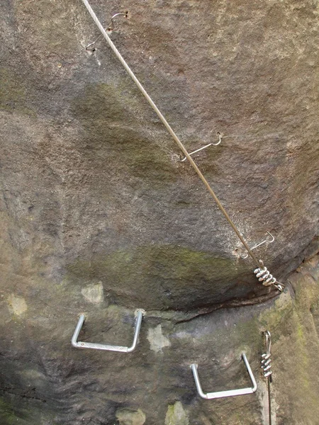 Bergsteiger-Weg. Eisen gedrehten Seil im Block durch Schrauben Karabinerhaken befestigt. das im Sandsteinfelsen verankerte Seil. — Stockfoto