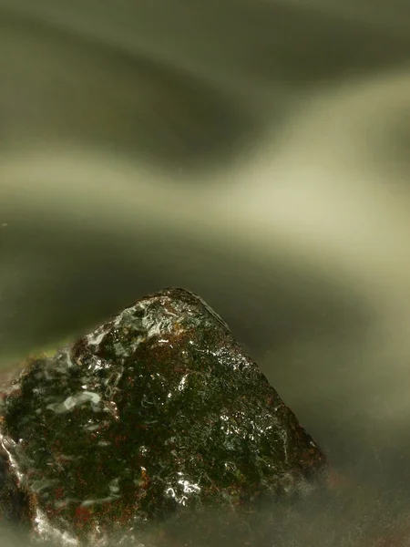 Wet boulder in mountain stream. Clear water blurred by long exposure, reflection in water level. — Stock Photo, Image