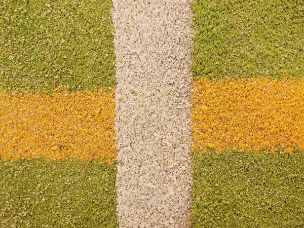 Colorful lines in empty outdoor handball playground, plastic light green surface on ground and white, red and blue bounds lines.