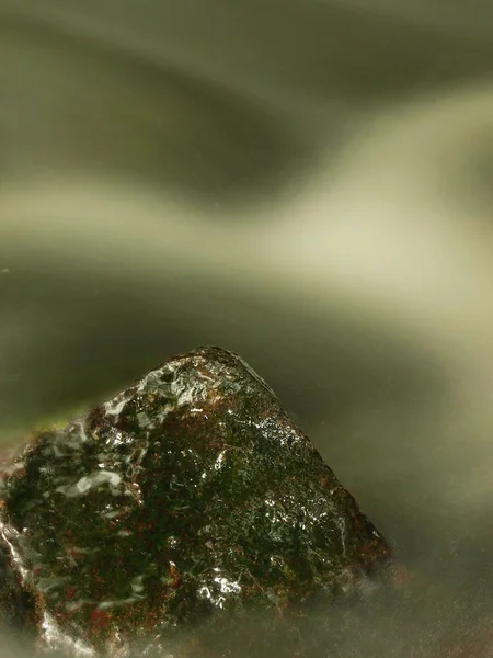 Roca mojada en el arroyo de montaña. Agua clara borrosa por la exposición prolongada, reflejos agudos en el nivel del agua . — Foto de Stock